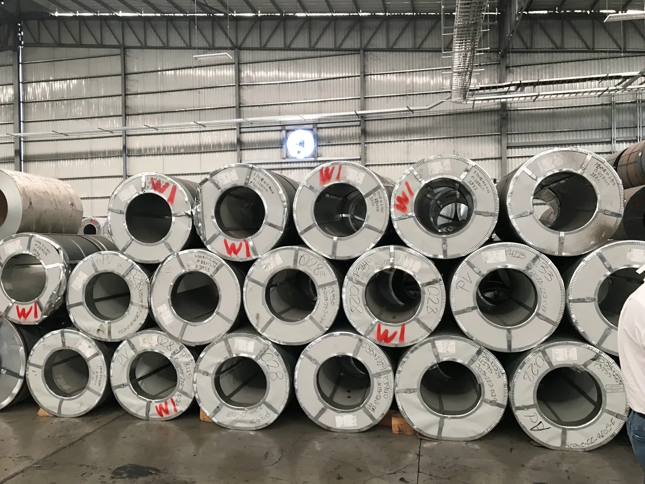 Hot-rolled steel coil stacks in a steel trading warehouse